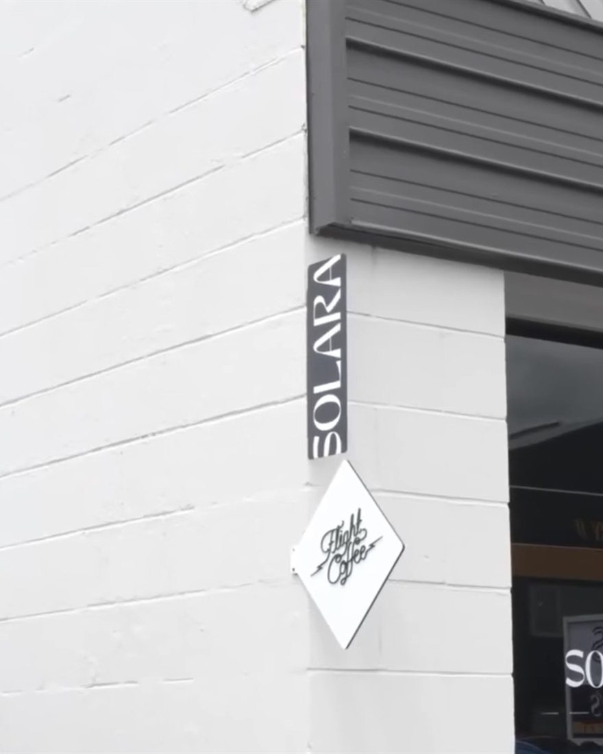 The black SOLARA sign on the corner of the building, above the entrance