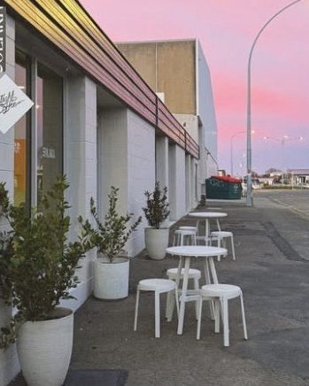 Solara's street frontage at dusk, with tables and stools out on the footpath